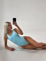 Блондинка в блакитному купальнику робить селфі лежачи